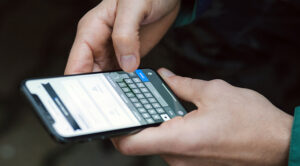 Close up of a person's hands hold their mobile phone, typing out a message