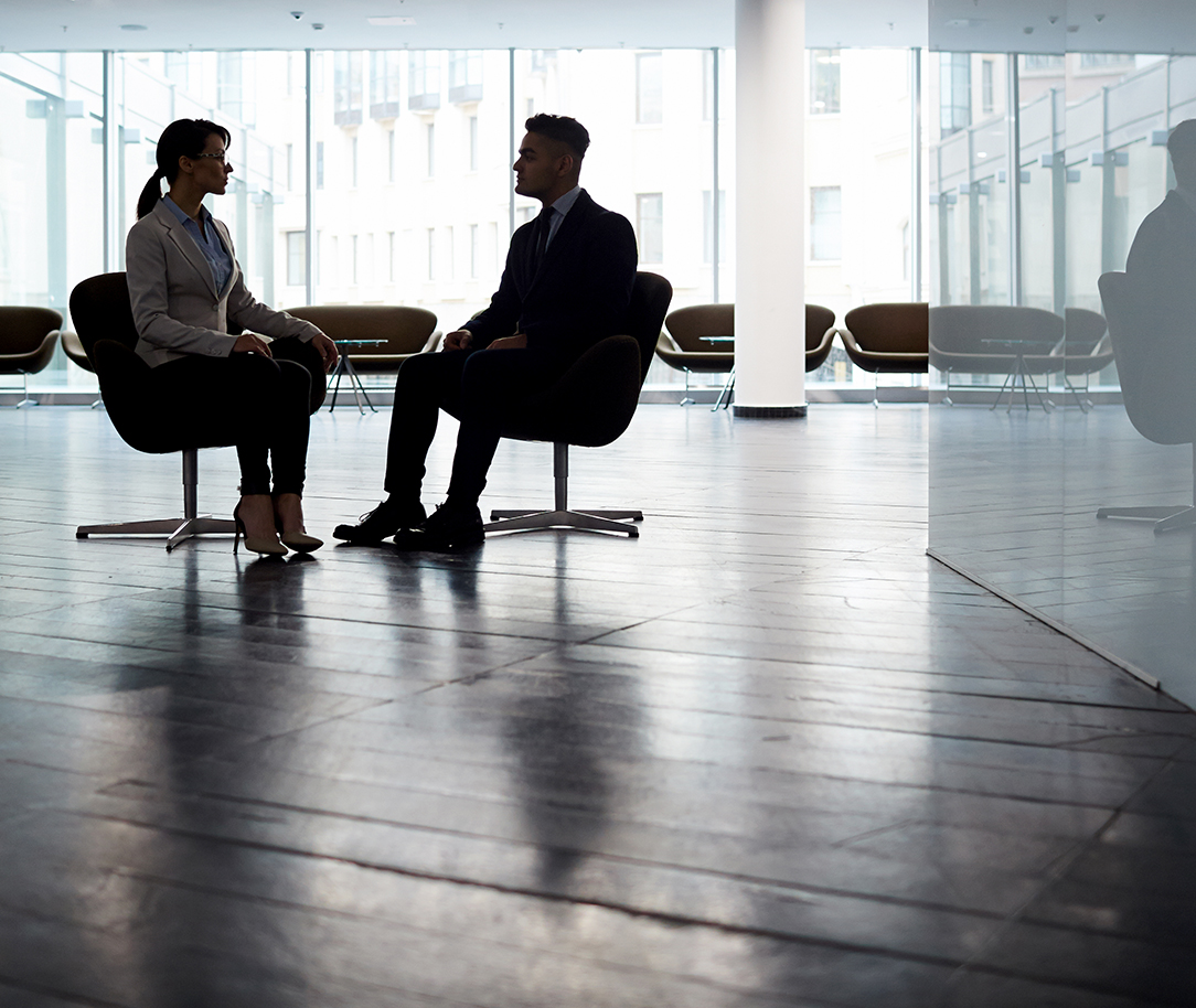 Two persons sitting in front of each other